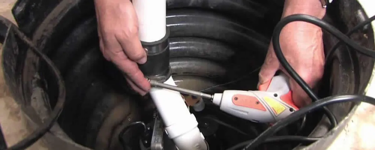 Sump pump installation technician connecting PVC discharge piping in Reno, NV